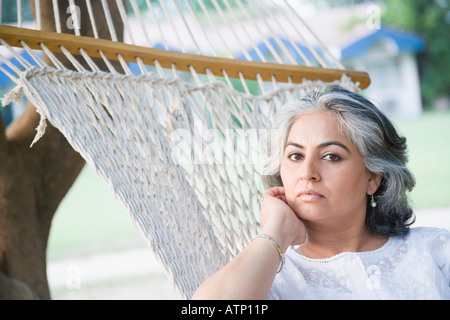 Portrait of a mature woman reclining in a hammock and thinking Stock Photo