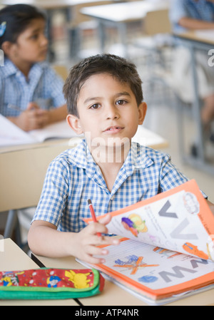 Portrait of a schoolboy sitting in a classroom Stock Photo