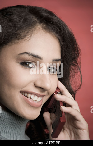 Portrait of a young woman talking on a mobile phone and smiling Stock Photo