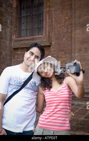 Young couple making a film of themselves with a home video camera, Goa, India Stock Photo