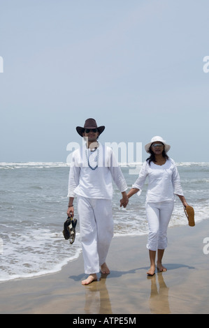 Young couple walking with holding hands on the beach Stock Photo