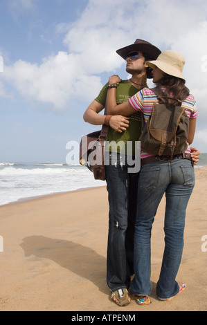 Young couple standing on the beach and embracing each other Stock Photo