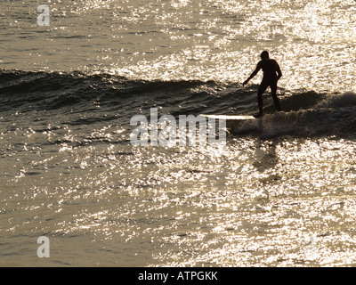 Surfer at sunset Cornwall UK Stock Photo