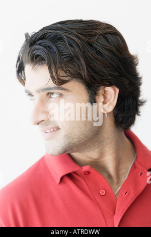 Close-up of a young man looking sideways and smiling Stock Photo