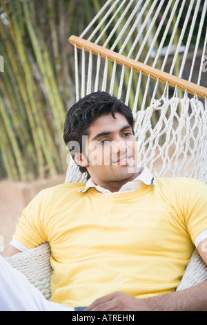 Young man lying in a hammock and smiling Stock Photo