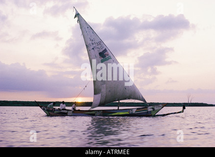 A traditional Luo sailing canoe with Jaluo fishermen on board setting off at dawn to fishing grouhds on Lake Victoria Kenya Stock Photo