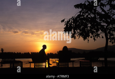 Kampot a couple enjoying the sunset at the banks of the Prek Kompong river Stock Photo