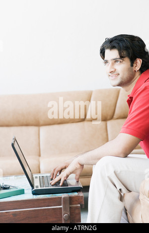 Side profile of a young man using a laptop Stock Photo