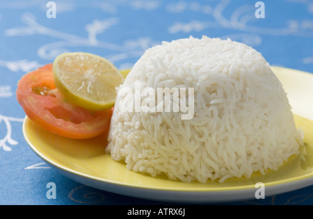 Close-up of white rice in a plate with slices of lemon and tomato Stock Photo