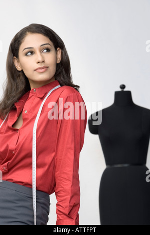 Side profile of a female designer with a measuring tape around her neck Stock Photo