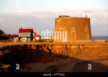 Martello Tower and house at East Bawdsey Suffolk England in danger of sliding into the north sea due to coastal erosion Stock Photo