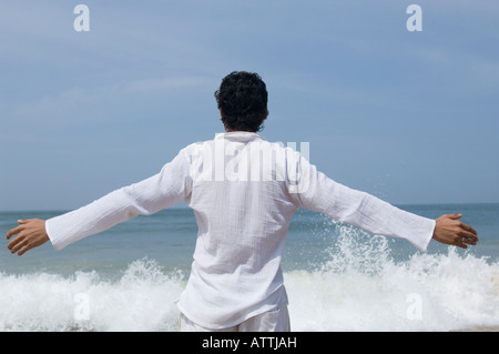 Rear view of a young man standing on the beach Stock Photo