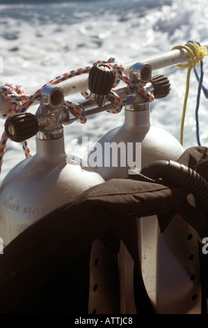 Manifolded twin scuba diving cylinders tied on rail of dive boat Stock Photo