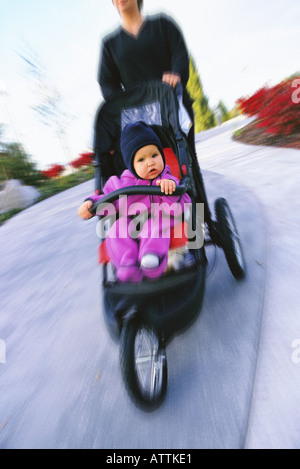 Mother pushing baby in stroller Stock Photo