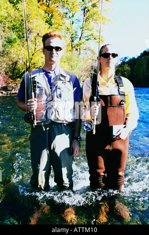 Portrait of couple holding fishing rods Stock Photo