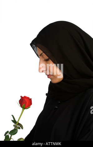 Muslim woman wearing black hijab veil with red rose Stock Photo