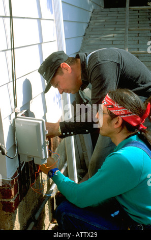 Men age 40 working together on telephone box. St Paul Minnesota USA Stock Photo