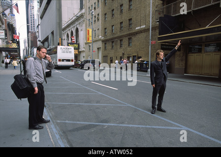 A doorman hails a cab, midtown Manhattan Stock Photo