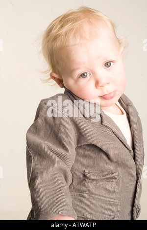 A toddler boy makes a pouty face in the studio Stock Photo