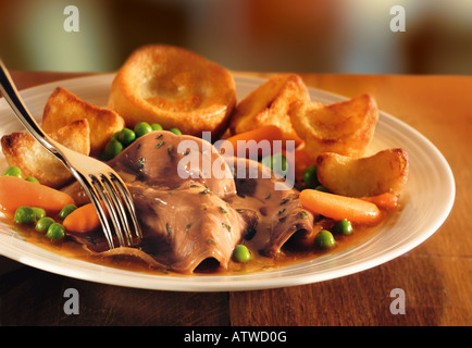 Traditional roast lamb dinner with roast potatoes and yorkshire pudding Stock Photo