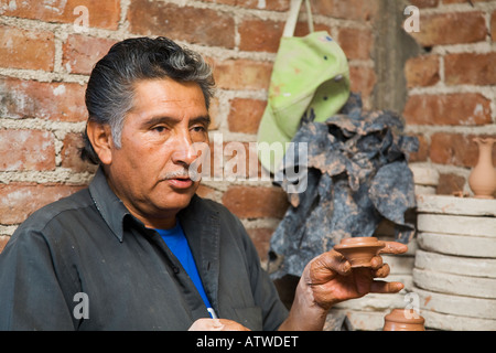 MEXICO Guanajuato Mexican male potter showing lid to pot shaped from clay on throwing wheel Stock Photo