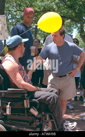 Senator Paul Wellstone talking with handicapped man in wheelchair age 35 at AIDS Walk ceremony. St Paul Minnesota USA Stock Photo