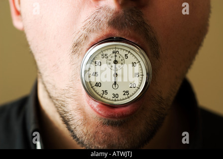 Man with chronometer stopwatch in his mouth Stock Photo