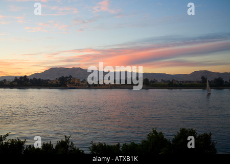 River Nile at dawn from Luxor east bank looking to Theban Mountains and Valley of the Kings Egypt North Africa Stock Photo