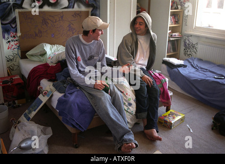 Two teenage friends smoking drinking and chatting in bedroom.