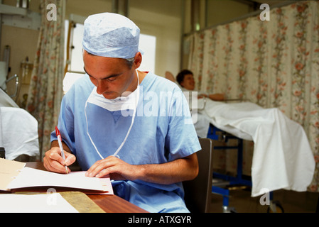 Surgeon in operating room writing notes. Stock Photo