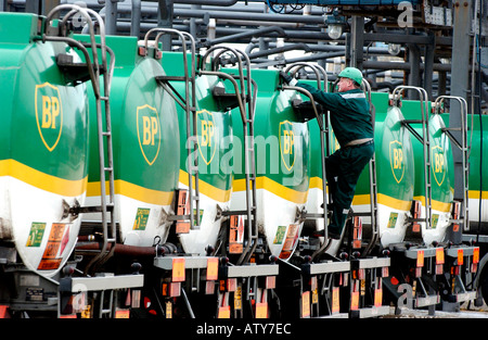 BP tanker lineup with man in green hard hat climbing access ladder at back of tank Stock Photo