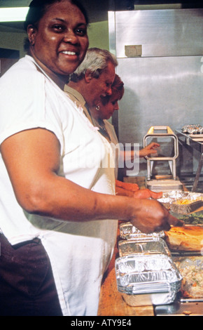 Volunteers at senior citizens center prepare meals to deliver for Meals on Wheels program Stock Photo