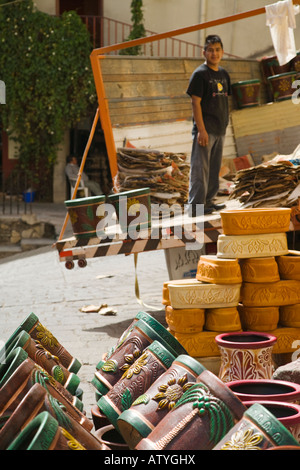 MEXICO Guanajuato Mexican young adult standing on truck bed in street unloading pottery for retail store Stock Photo