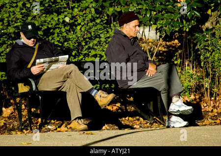 2 men sitting on bench in london park Stock Photo