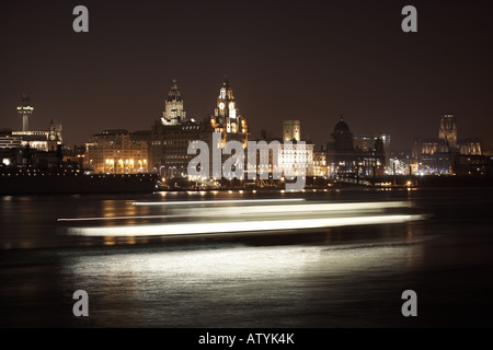 Liverpool skyline at night has seen from over the River Mersey with the movement of the ferry passing by Stock Photo