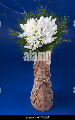 Spring holiday snowdrop flower bouquet in clay vase. Three shots stitch image. Stock Photo