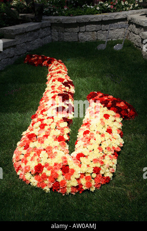 Image of large saxophone laid out on grass and made entirely of yellow pink and red carnations.  Philadelphia flower show 2008. Stock Photo