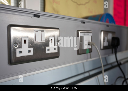 uk three pin polished metal double electrical socket and internet connection in service conduit in a classroom belfast Stock Photo