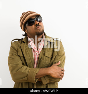 African American mid adult man wearing hat and sunglasses with arms crossed looking up Stock Photo