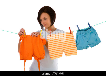 Young smiling woman hanging clothes on clothesline using clothespin Front view white background White background Stock Photo