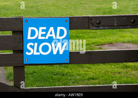 A cautionary Dead Slow sign on a brick wall in London, highlighting a ...