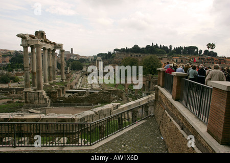 Tourists gather at a high viewing point to gaze over the Imperial Roman Forum ruins and the temple of Saturn, Rome Italy Europe Stock Photo