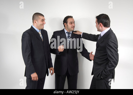 3 Three business men in suits talking Stock Photo
