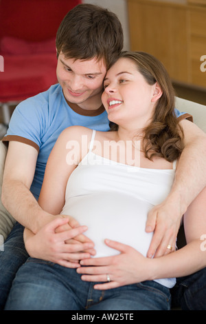 Pregnant woman and partner hugging Stock Photo