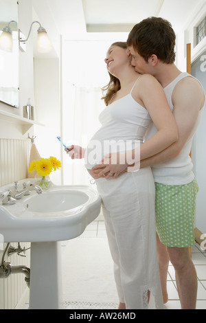 Man kissing pregnant partners neck Stock Photo