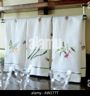 hand embroidered cotton towels arranged on rail in a kitchen Stock Photo