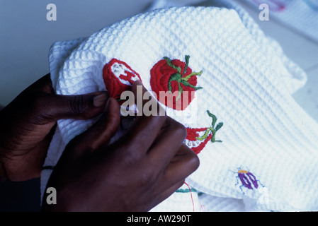 Detail of black hands embroidering fruit on a waffle tea towel Stock Photo