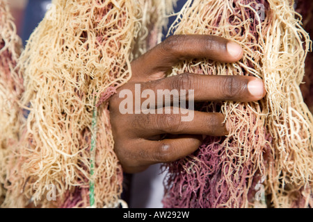 Hand holding wet Seaweed hanging out to dry Chwaka village Zanzibar Tanzania Stock Photo