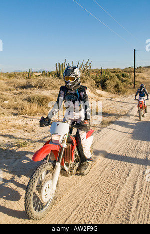 Mature adult Female off road motorcycle rider on dirt road in Baja California, Mexico Stock Photo