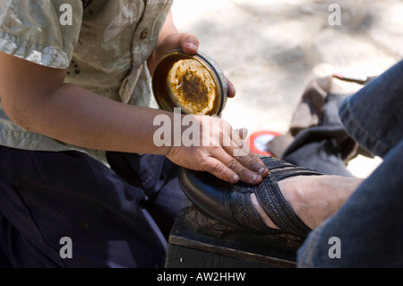 Mexican boy working hard to polish shoes in Chiapas Mexico Stock Photo